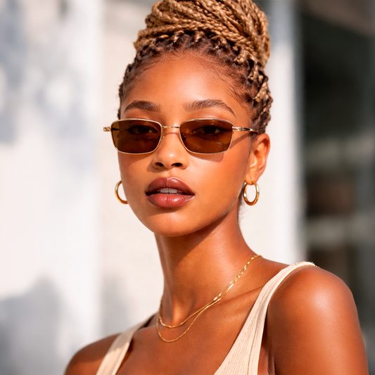 Gafas de sol rectangulares Cannes Riviera con montura metálica fina dorada y lentes en tono marrón cálido.