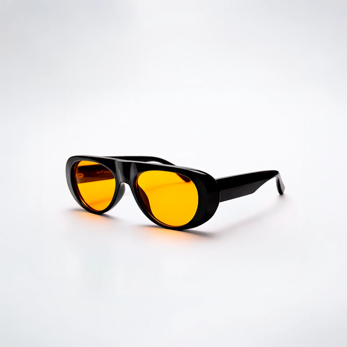 Gafas de sol ovaladas de montura gruesa negra Venice Sunset con lentes en tono amarillo naranja brillante.