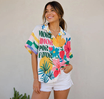 Camisa oversized vibrante con mensaje "More Amor", flores tropicales y arte inspirado en Frida. Una pieza alegre y única para tu armario. ¡Consíguela en Badhabitsx!
