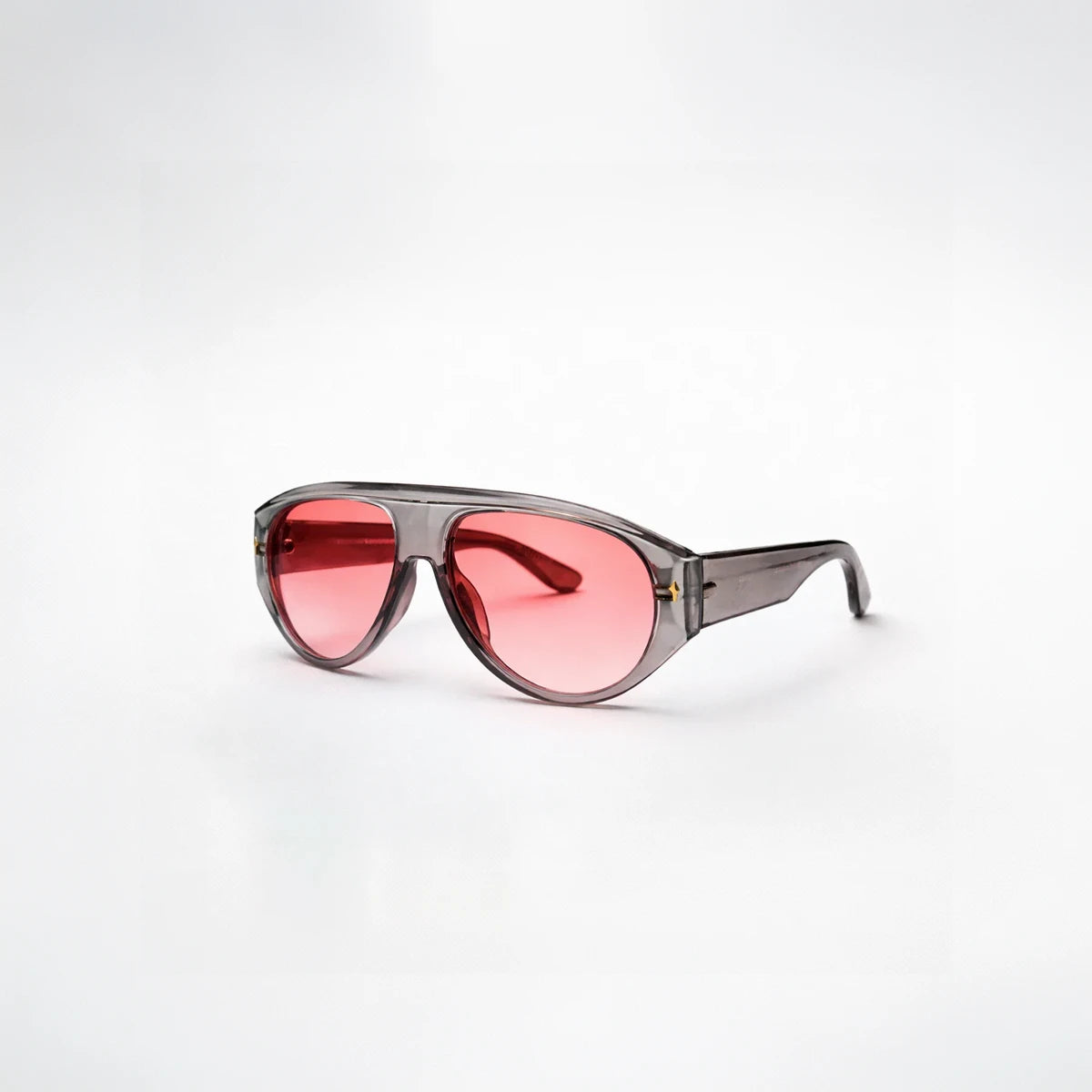 Gafas de sol de estilo aviador Barcelona Rose con montura gris translúcida y lentes en tono rosado brillante.

