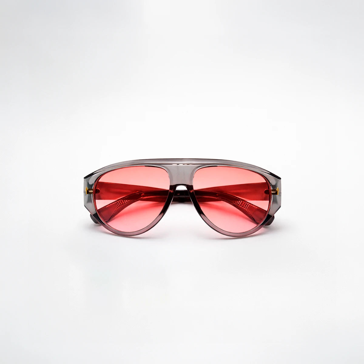 Gafas de sol de estilo aviador Barcelona Rose con montura gris translúcida y lentes en tono rosado brillante.
