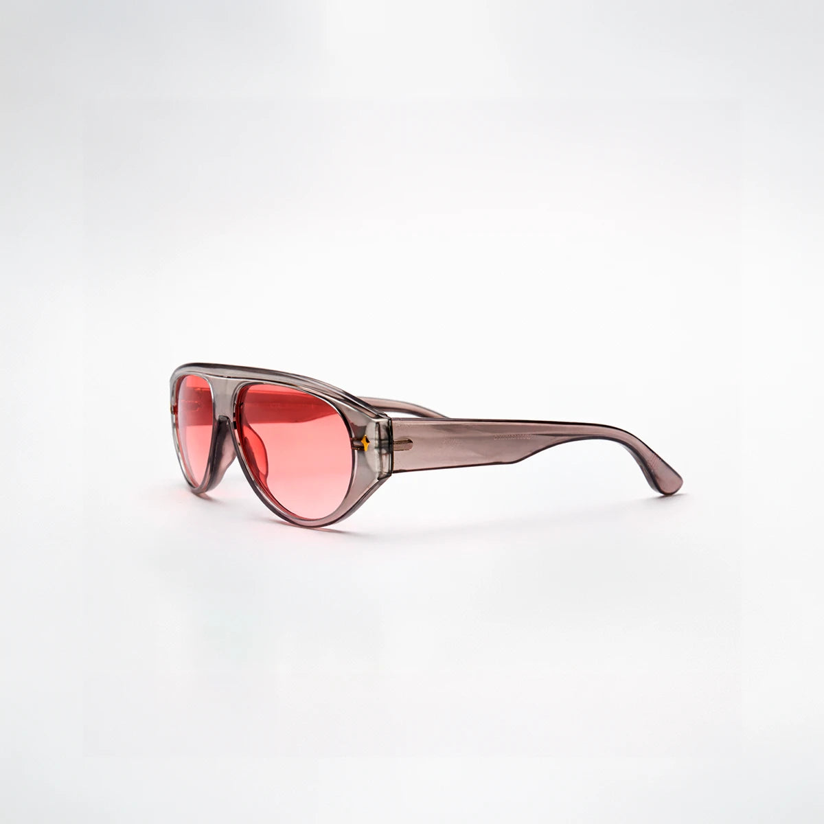 Gafas de sol de estilo aviador Barcelona Rose con montura gris translúcida y lentes en tono rosado brillante.
