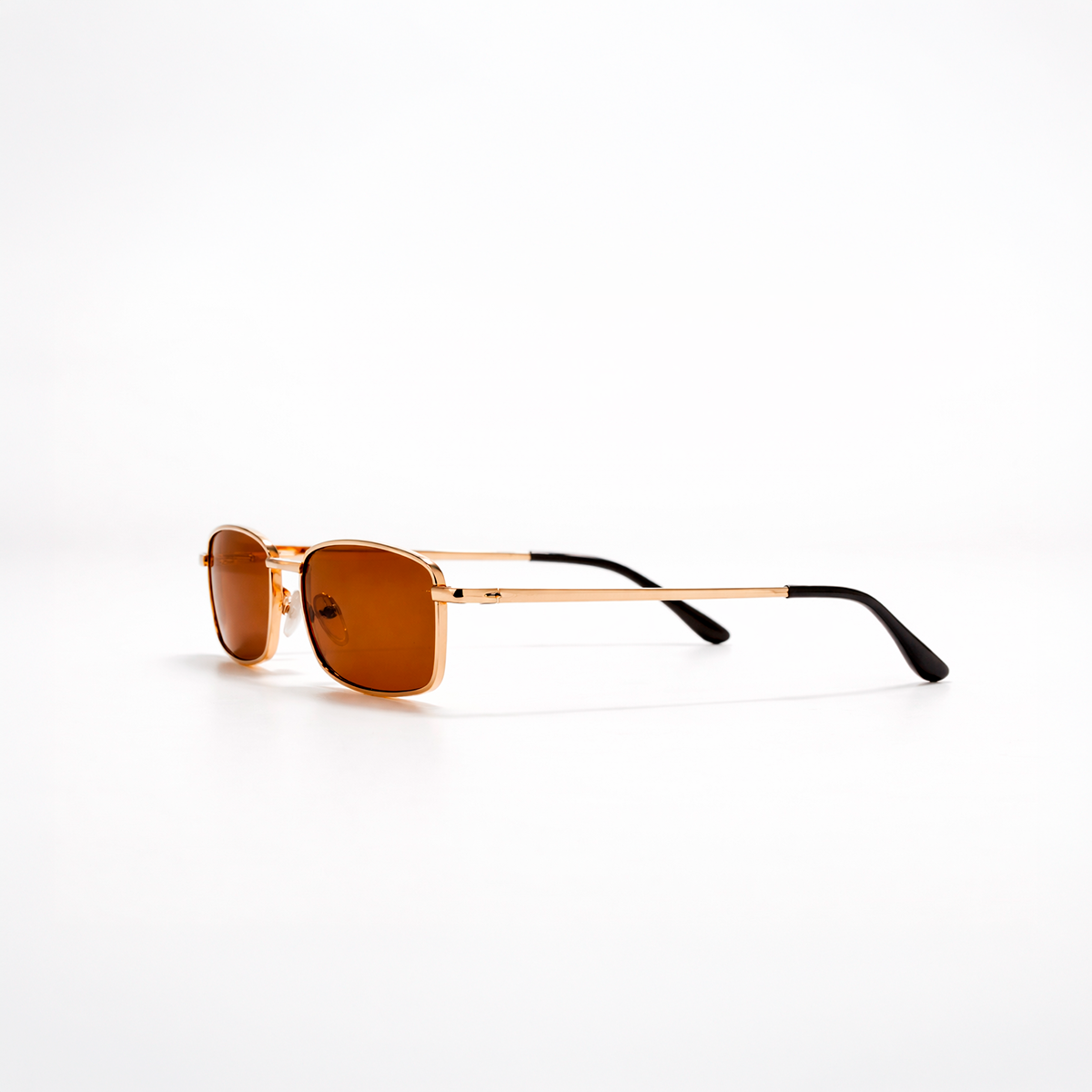 Gafas de sol rectangulares Cannes Riviera con montura metálica fina dorada y lentes en tono marrón cálido.
