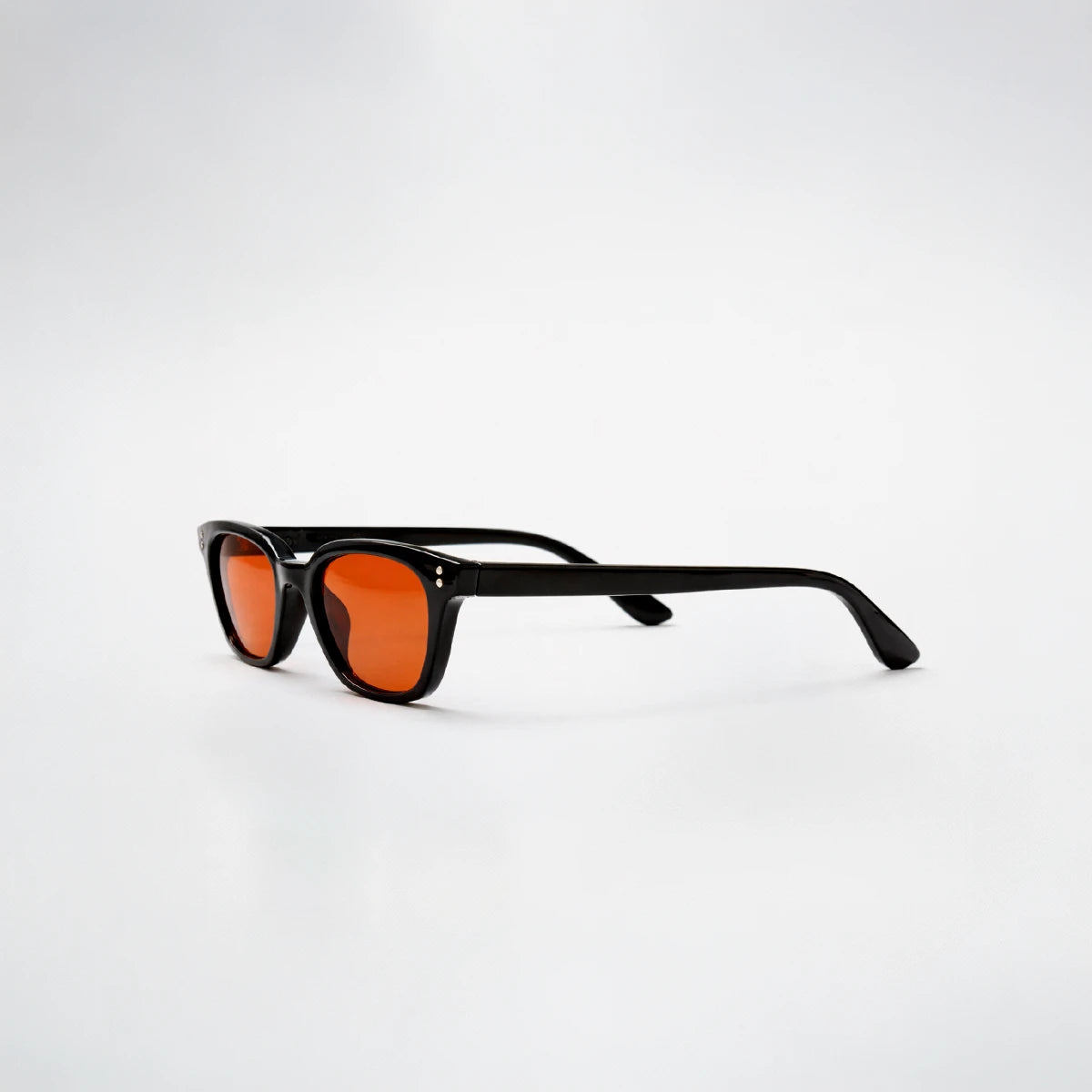Gafas de sol rectangulares Capri Sunset con montura gruesa negra y lentes en tono naranja brillante.
