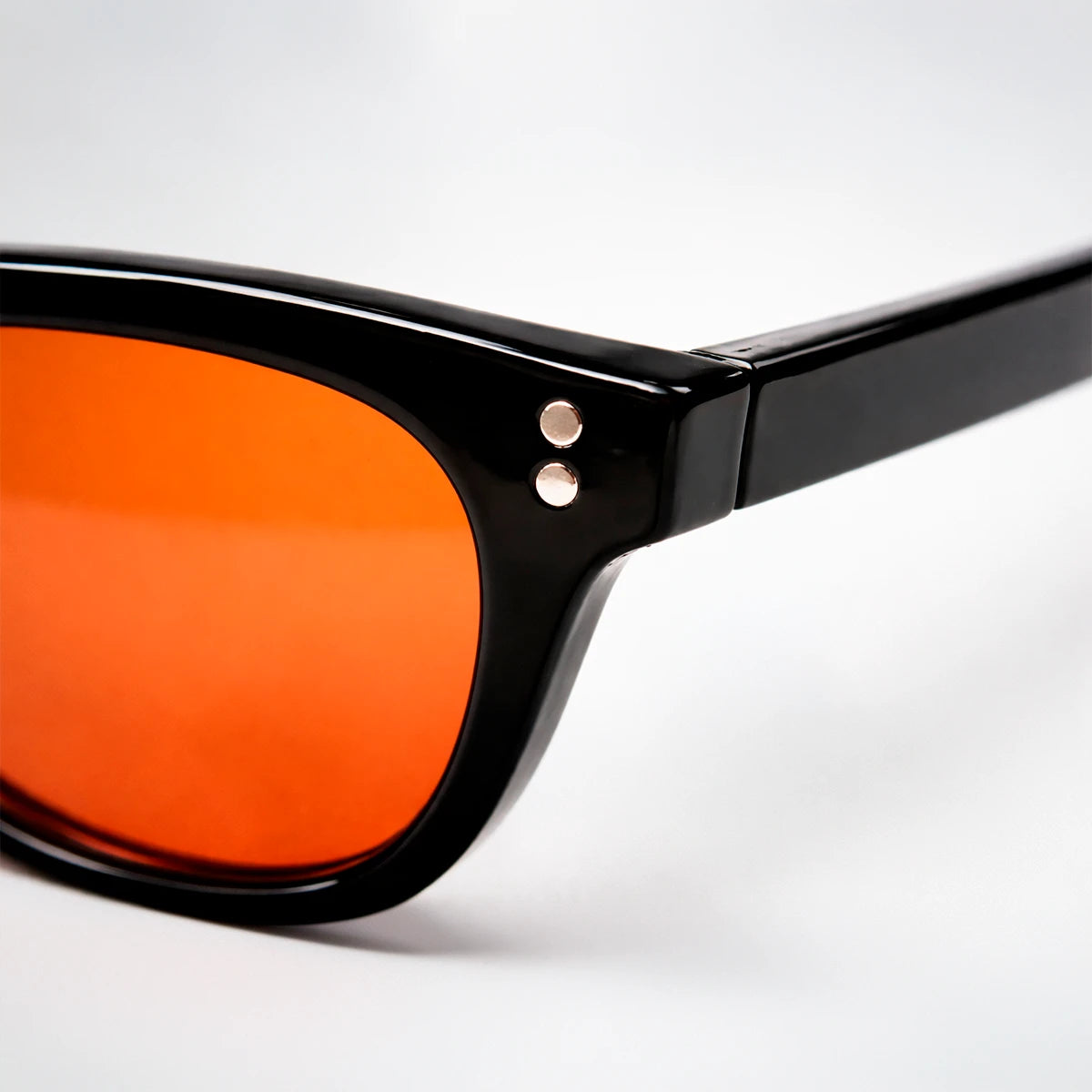 Gafas de sol rectangulares Capri Sunset con montura gruesa negra y lentes en tono naranja brillante.
