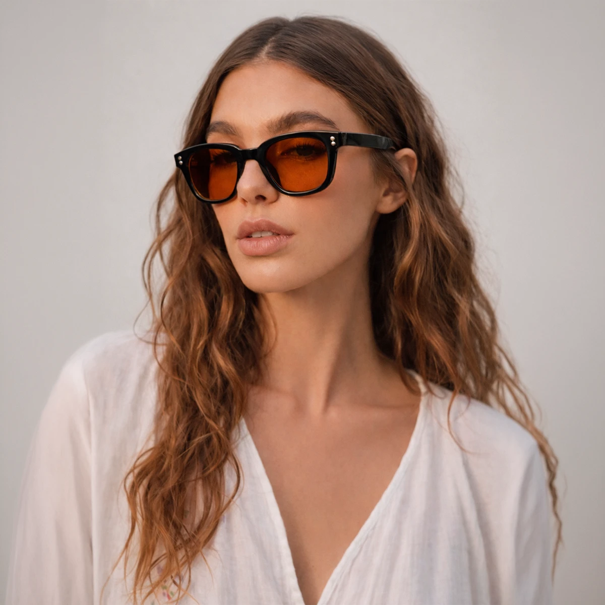 Gafas de sol rectangulares Capri Sunset con montura gruesa negra y lentes en tono naranja brillante.
