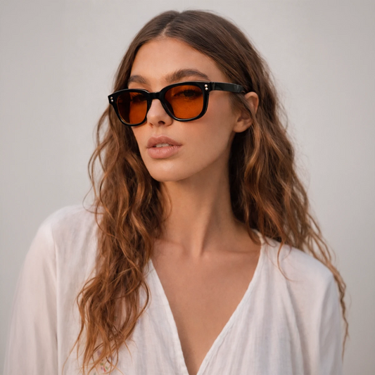 Gafas de sol rectangulares Capri Sunset con montura gruesa negra y lentes en tono naranja brillante.
