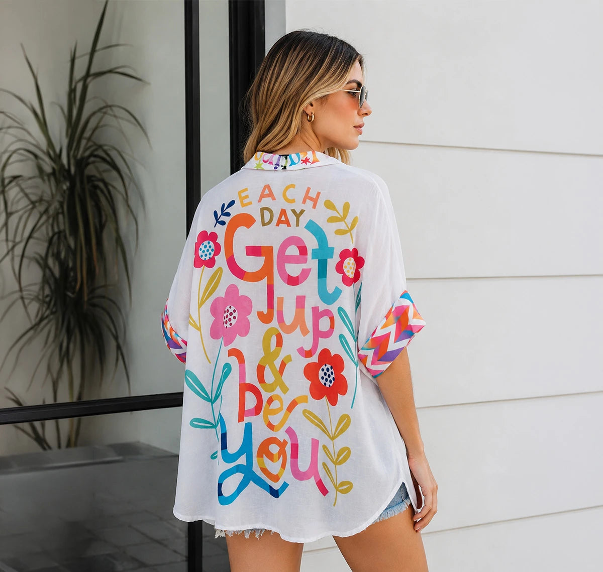 Camisa oversized con ilustraciones naïf, corazones folk y mensaje optimista. Diseño artístico y vibrante para un verano con estilo. ¡Cómprala en Badhabitsx!