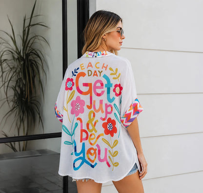 Camisa oversized con ilustraciones naïf, corazones folk y mensaje optimista. Diseño artístico y vibrante para un verano con estilo. ¡Cómprala en Badhabitsx!