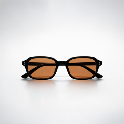 Gafas de sol rectangulares Lisbon Honey con montura gruesa negra y lentes en tono ámbar miel.
