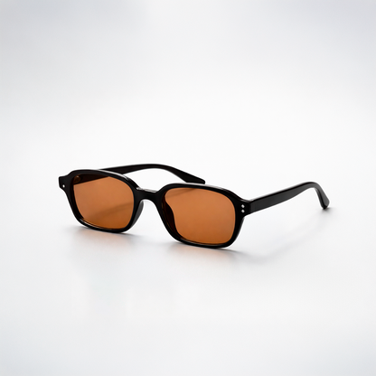 Gafas de sol rectangulares Lisbon Honey con montura gruesa negra y lentes en tono ámbar miel.
