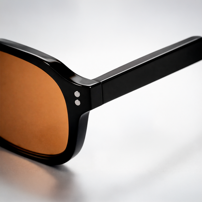  Gafas de sol rectangulares Lisbon Honey con montura gruesa negra y lentes en tono ámbar miel.
