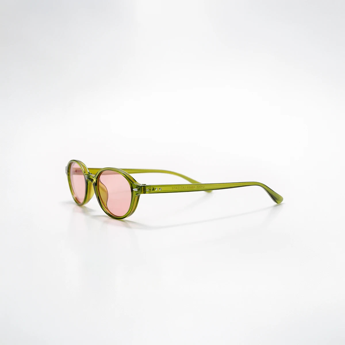 Detalle de la montura verde oliva translúcida y lentes rosas de las gafas de sol London Rose.
