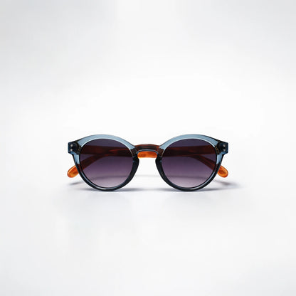 Gafas de sol redondeadas Paris Fade con montura azul translúcida, patillas de carey ámbar y lentes en degradado violeta.
