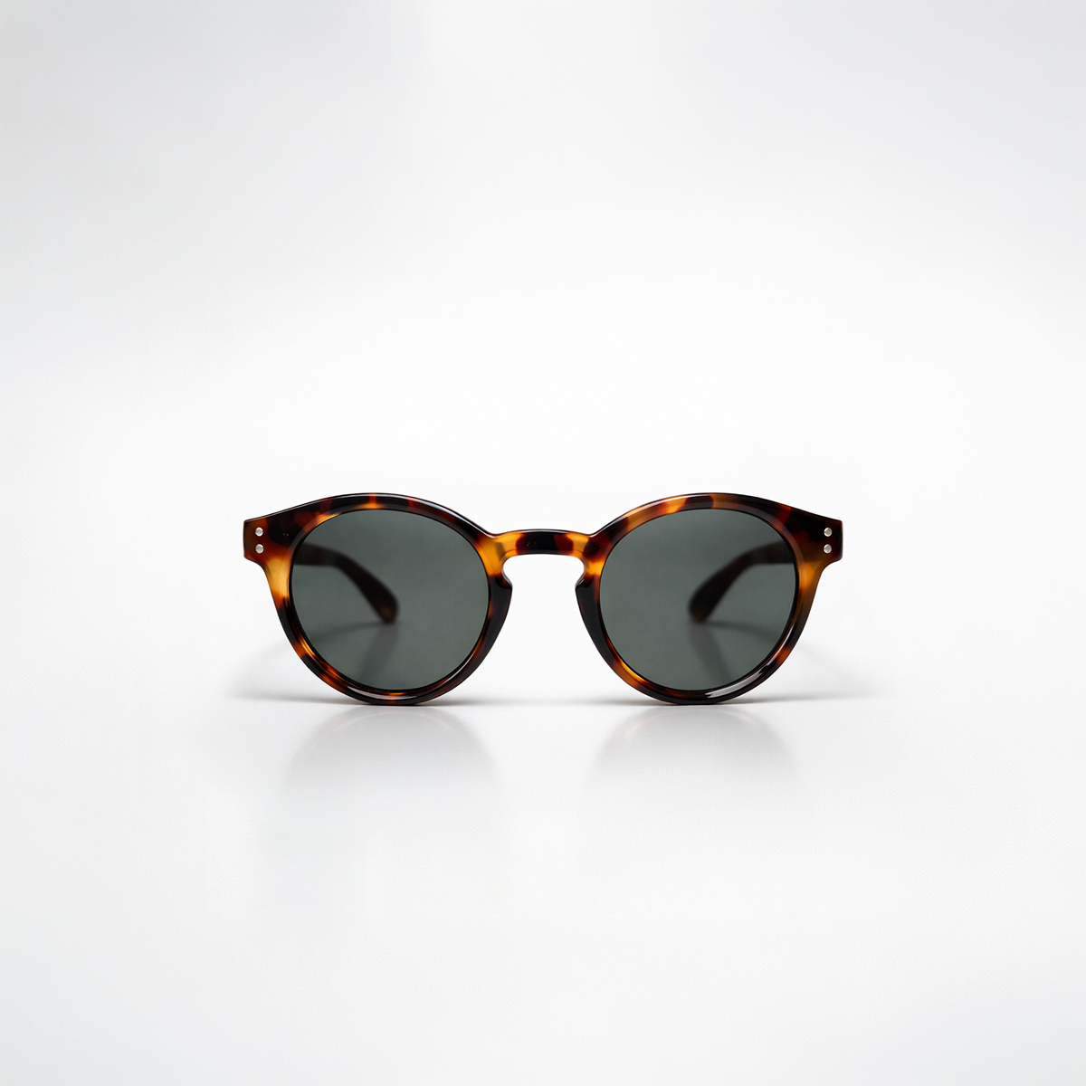 Gafas de sol redondeadas Paris Tortoise con montura en carey oscuro de diseño atemporal y lentes de sol gris oscuro.
