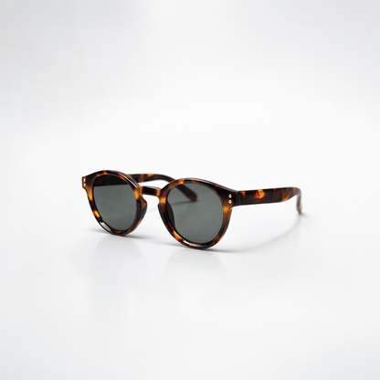 Gafas de sol redondeadas Paris Tortoise con montura en carey oscuro de diseño atemporal y lentes de sol gris oscuro.
