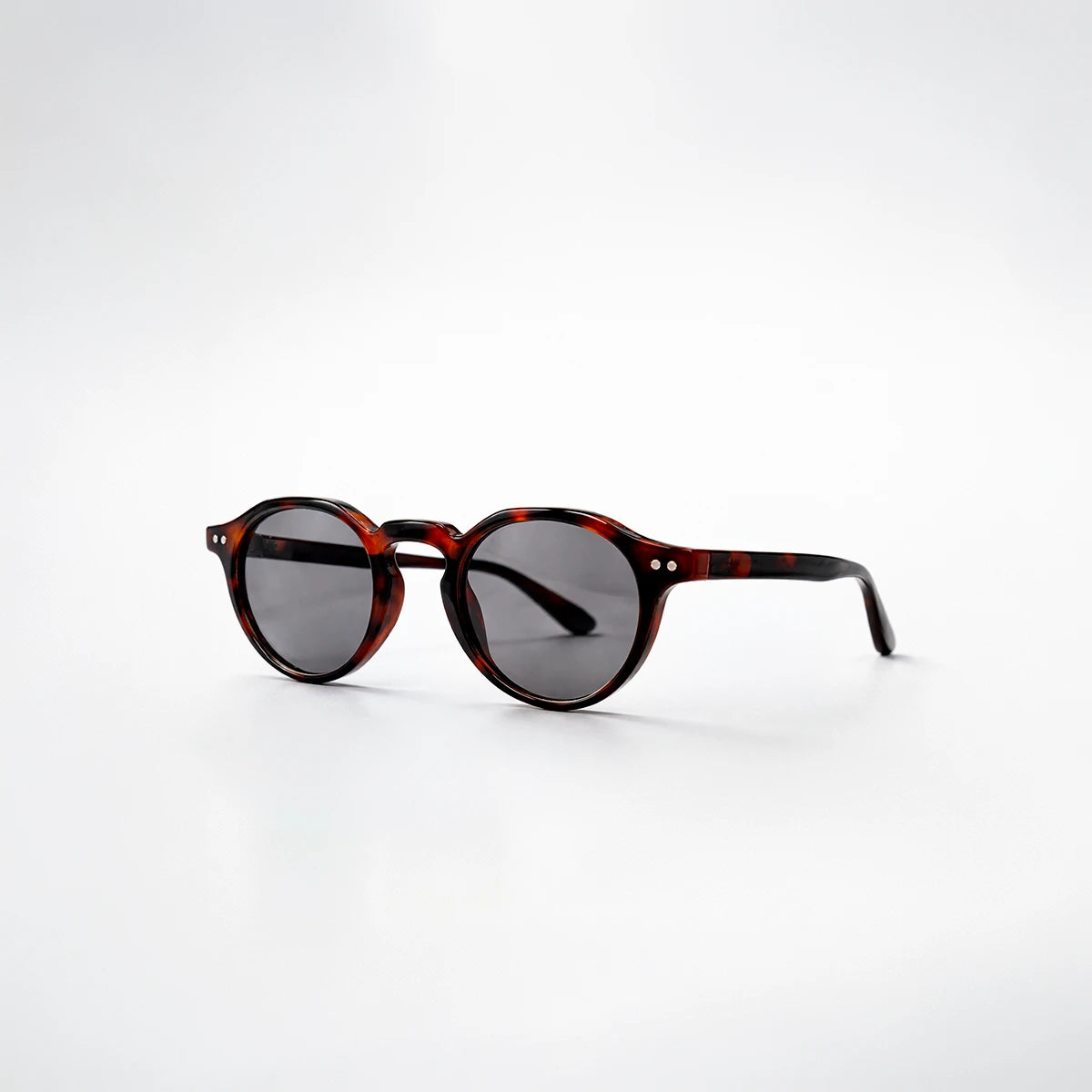 Gafas de sol redondeadas Rome Smoke con montura de carey oscuro y lentes en color gris humo.