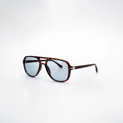 Gafas de sol de carey oscuro Santorini Blue con lentes de sol de tono azul frío y montura definida.
