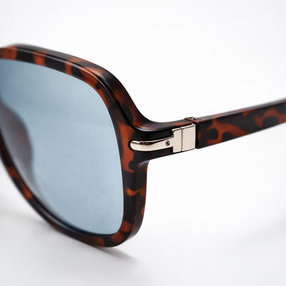 Gafas de sol de carey oscuro Santorini Blue con lentes de sol de tono azul frío y montura definida.
