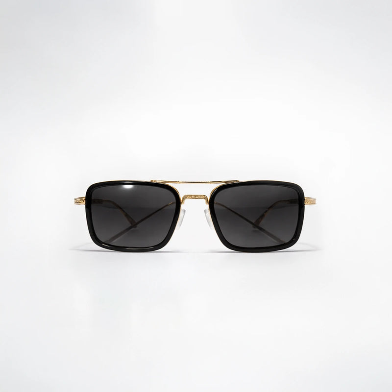 Gafas de sol redondeadas Soho Noir en color negro profundo con detalles en estructura metálica dorada y lentes gris oscuro.
