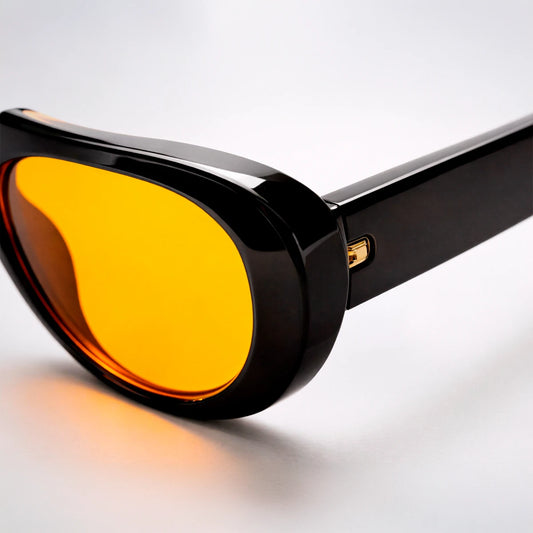 Gafas de sol ovaladas de montura gruesa negra Venice Sunset con lentes en tono amarillo naranja brillante.
